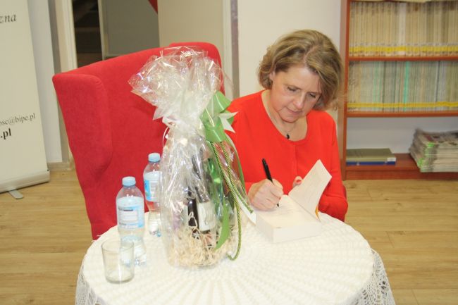 Monika Tadra pisze dedykację w książce dla czytelniczki.