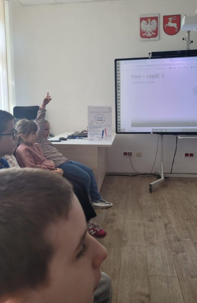 dziewczynka zgłasza się do odpowiedzi, podnosząc rękę do góry