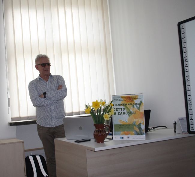 Marek Kołcon omawia zdjęcie wyświetlone na tablicy multimedialnej.