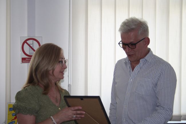 Wicedyrektor Biblioteki Pedagogicznej wręcza Markowi Kołconowi pamiątkowy plakat.