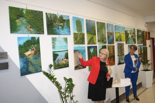 Regina Grzybowska omawia swoje prace prezentowane na wystawie w Bibliotece Pedagogicznej w Zamościu.