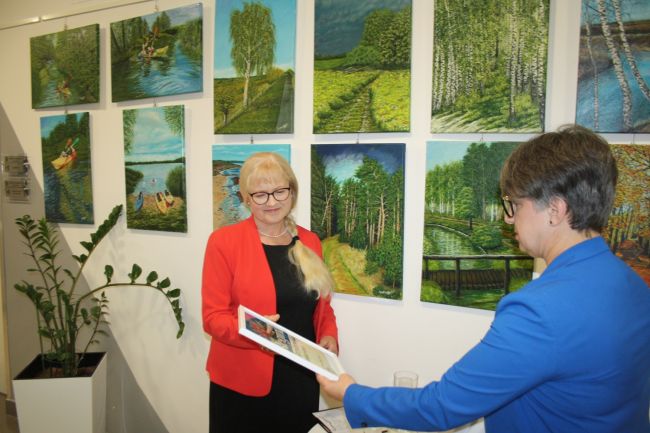 Dyrektor Biblioteki Pedagogicznej w Zamościu wręcza Reginie Grzybowskiej pamiątkowy plakat wystawy.
