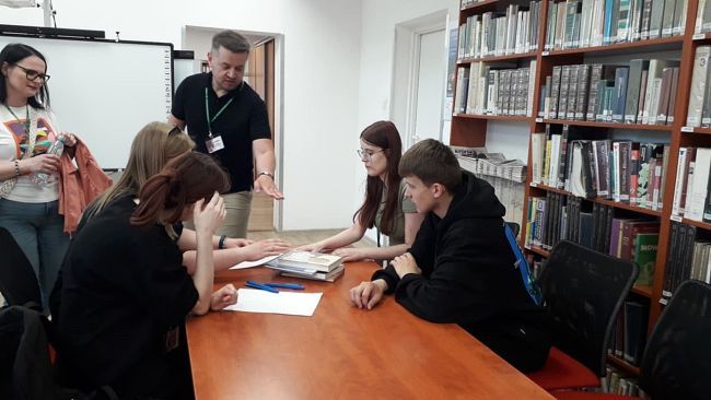 Uczestnicy gry miejskiej podczas wykonywania zadania.